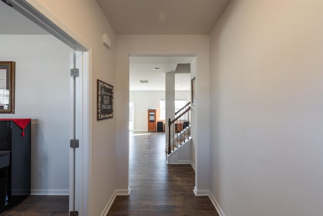 hallway featuring visible vents, dark wood finished floors, stairway, and baseboards