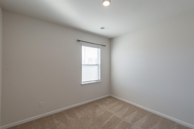 unfurnished room with light colored carpet, visible vents, and baseboards