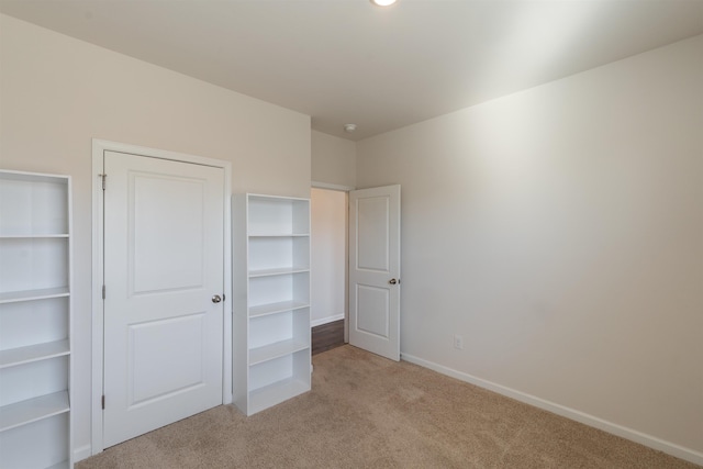 unfurnished bedroom with light carpet and baseboards