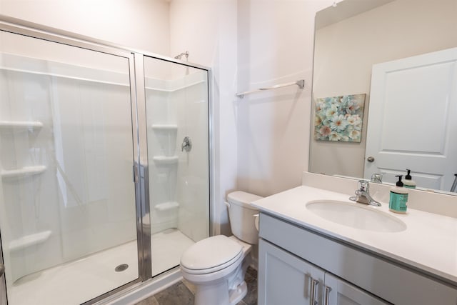 bathroom featuring toilet, a shower stall, and vanity