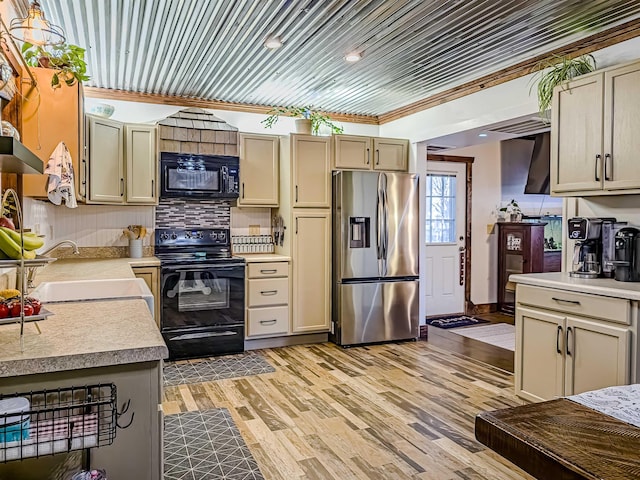 kitchen with backsplash, ornamental molding, sink, black appliances, and light hardwood / wood-style flooring