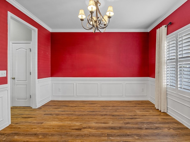 empty room featuring a healthy amount of sunlight, crown molding, a chandelier, and dark hardwood / wood-style floors