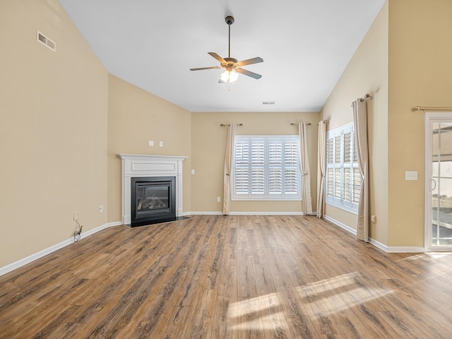 unfurnished living room with light wood-type flooring, vaulted ceiling, and ceiling fan