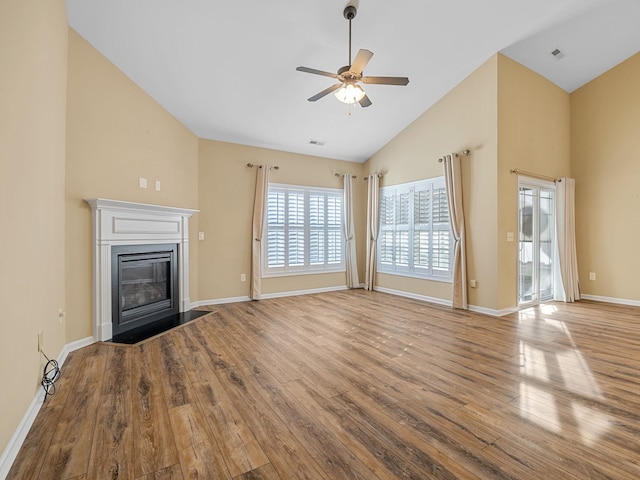 unfurnished living room featuring ceiling fan, high vaulted ceiling, and light wood-type flooring