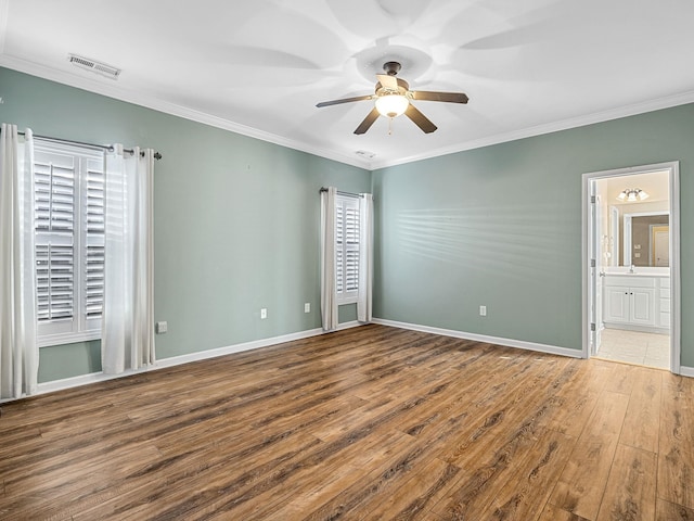 unfurnished bedroom featuring hardwood / wood-style flooring, ensuite bath, ceiling fan, and crown molding