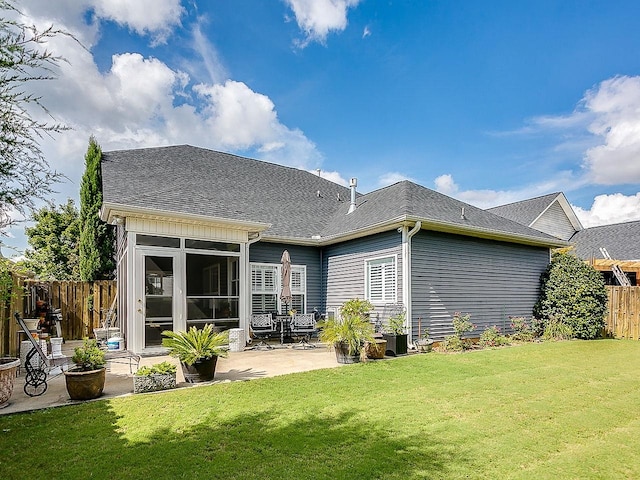 rear view of property featuring a yard and a patio area