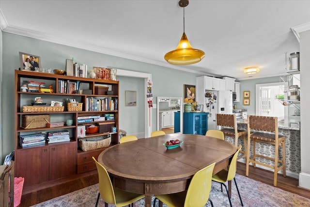 dining area with hardwood / wood-style flooring and ornamental molding