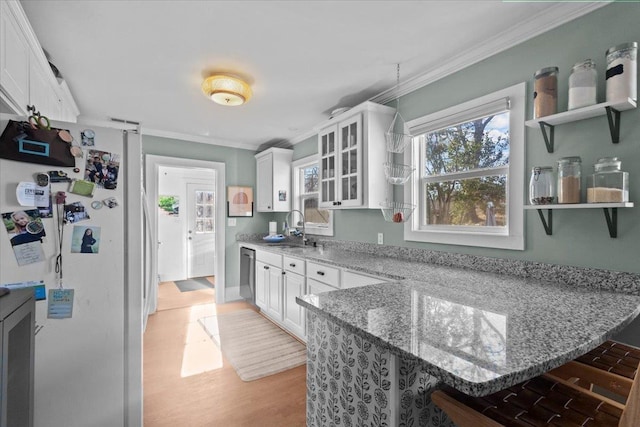 kitchen featuring white cabinets, white fridge, and ornamental molding