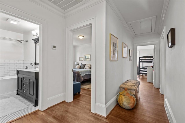 hallway featuring crown molding, hardwood / wood-style floors, and sink