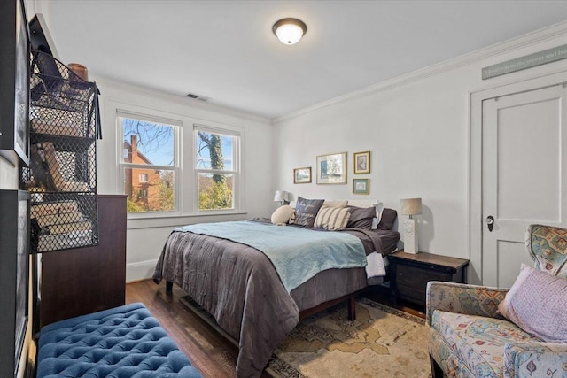 bedroom with dark wood-type flooring and ornamental molding