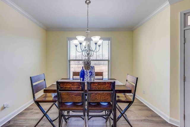 dining area with hardwood / wood-style floors, an inviting chandelier, and crown molding