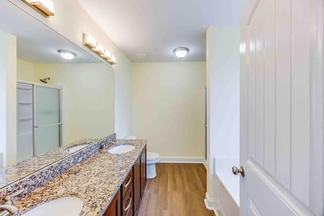 full bathroom with wood-type flooring, vanity, toilet, and independent shower and bath