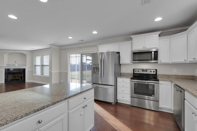 kitchen with light stone counters, dark hardwood / wood-style flooring, white cabinets, and appliances with stainless steel finishes