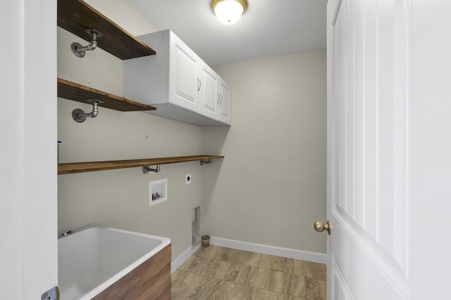 laundry area with electric dryer hookup, hookup for a washing machine, cabinets, and a textured ceiling