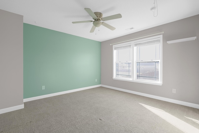 carpeted spare room featuring ceiling fan