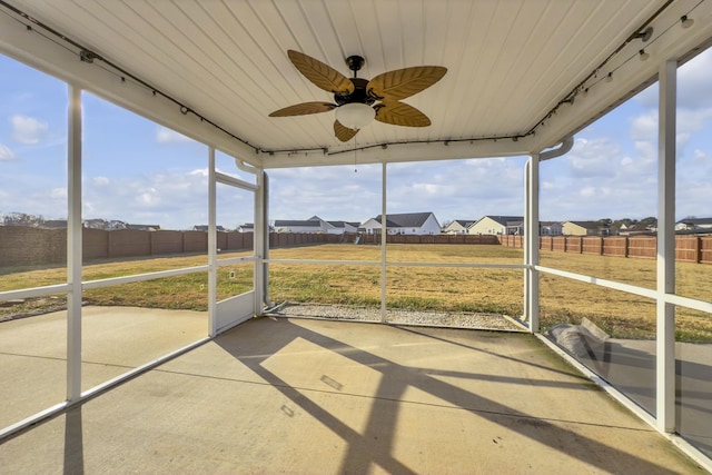 unfurnished sunroom featuring ceiling fan