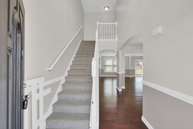 entrance foyer with dark wood-type flooring, a high ceiling, and decorative columns