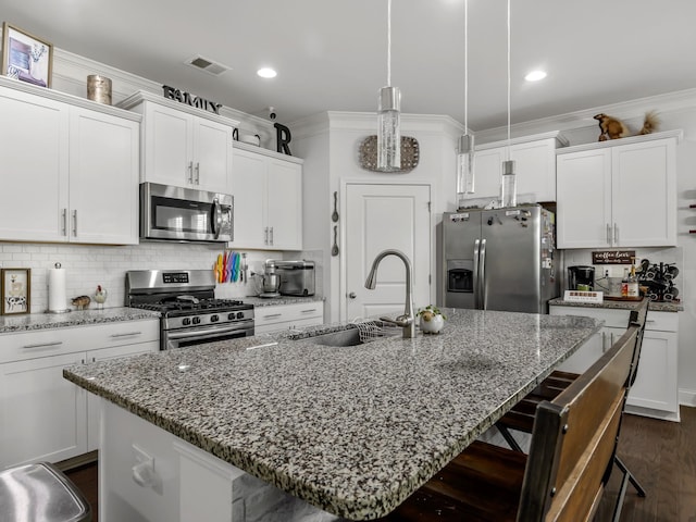 kitchen featuring a center island with sink, sink, white cabinetry, and stainless steel appliances