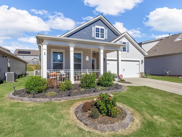 view of front of home with covered porch, a garage, cooling unit, and a front yard