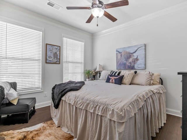 bedroom featuring ceiling fan, dark hardwood / wood-style flooring, crown molding, and multiple windows