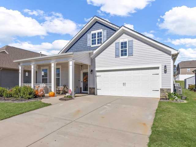 view of front of home featuring a garage, covered porch, and a front yard