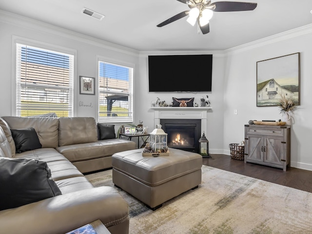 living room with dark hardwood / wood-style flooring, ceiling fan, and crown molding