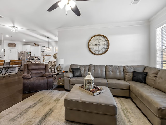 living room featuring hardwood / wood-style floors, ceiling fan, and crown molding