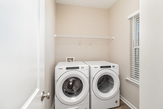 washroom with washing machine and clothes dryer and hardwood / wood-style flooring