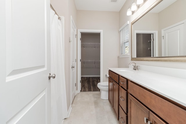 bathroom featuring vanity, toilet, and walk in shower