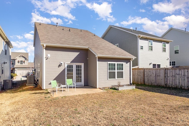 rear view of house featuring central air condition unit, a lawn, and a patio