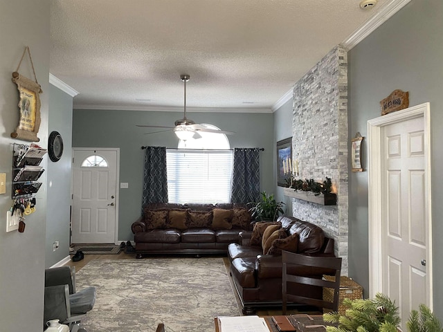 living room featuring ceiling fan, a textured ceiling, and ornamental molding