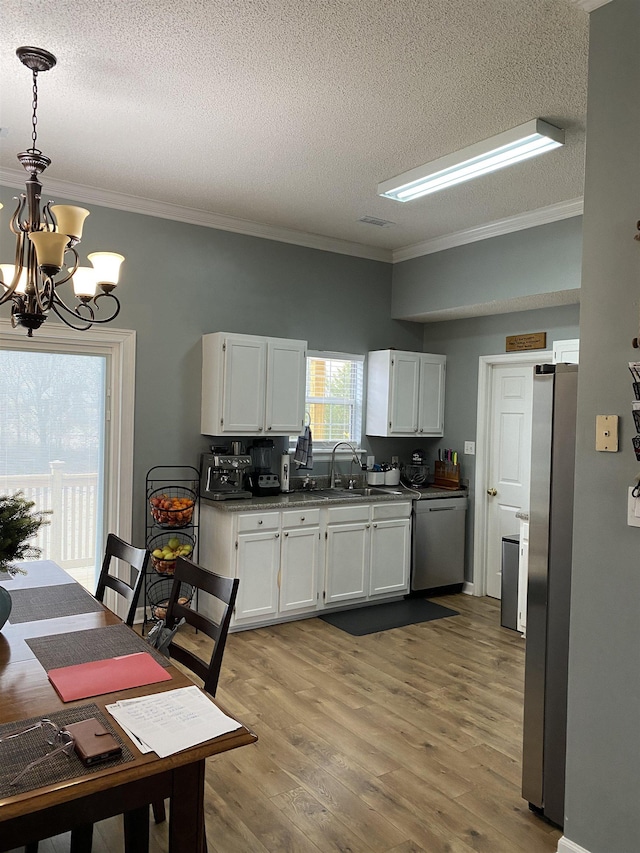 kitchen with white cabinetry, a textured ceiling, and an inviting chandelier