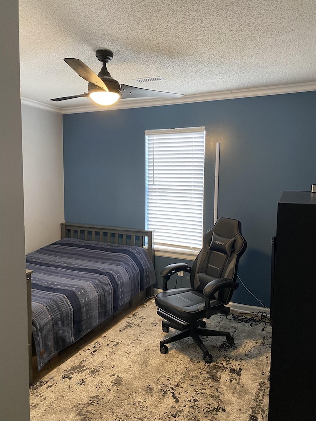 carpeted bedroom with a textured ceiling, ceiling fan, and crown molding