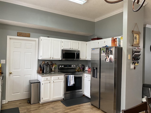 kitchen with white cabinetry, crown molding, a textured ceiling, appliances with stainless steel finishes, and light wood-type flooring