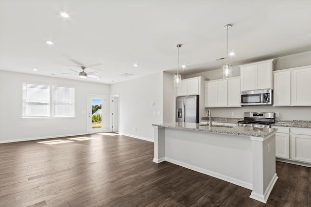 kitchen with a center island with sink, sink, decorative light fixtures, white cabinetry, and stainless steel appliances