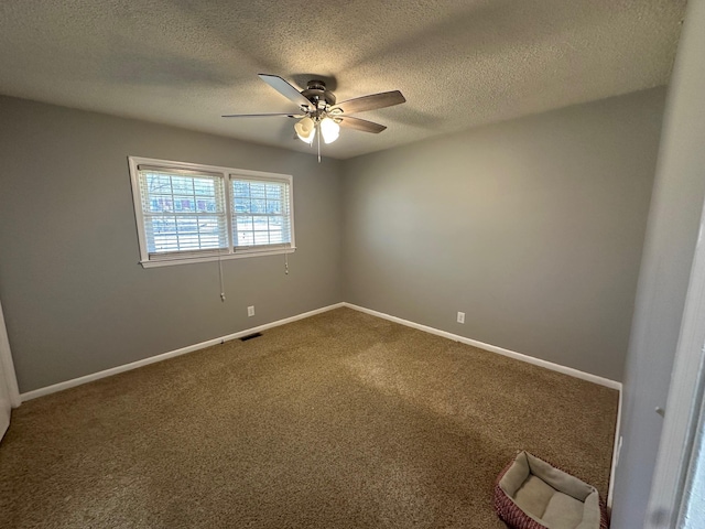 carpeted empty room with a textured ceiling and ceiling fan