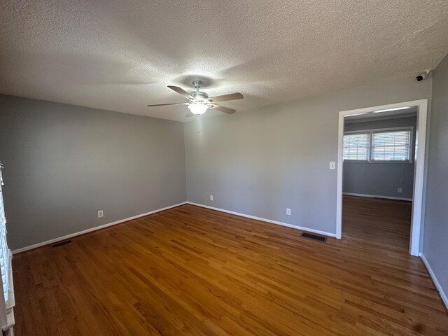 spare room featuring a textured ceiling, dark hardwood / wood-style floors, and ceiling fan