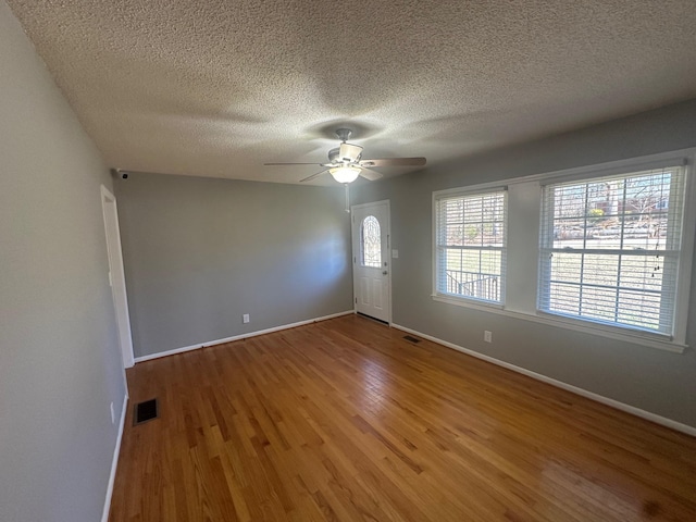 spare room featuring hardwood / wood-style floors, a textured ceiling, and ceiling fan