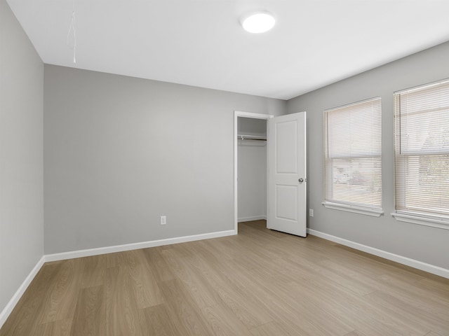 unfurnished bedroom featuring light wood-type flooring and a closet