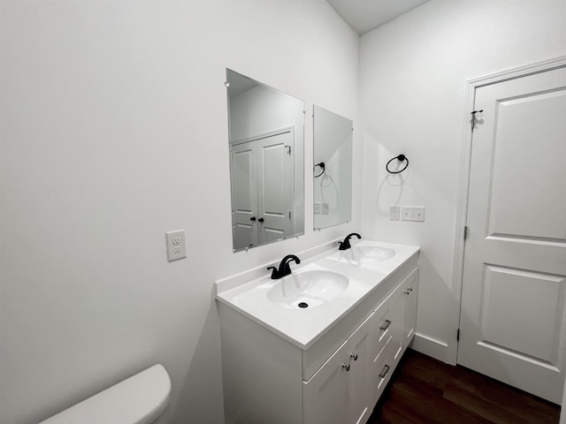 bathroom featuring vanity, hardwood / wood-style flooring, and toilet