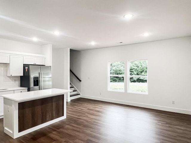 kitchen with white cabinetry, stainless steel fridge, and a center island