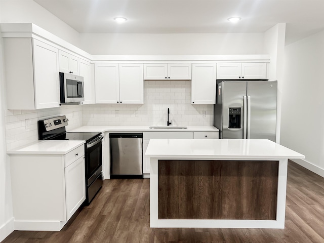 kitchen featuring appliances with stainless steel finishes, a center island, white cabinetry, and sink