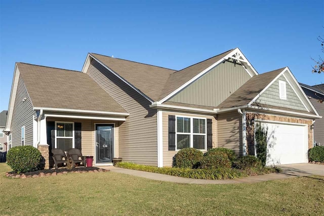 view of front of property featuring a front yard, a porch, and a garage