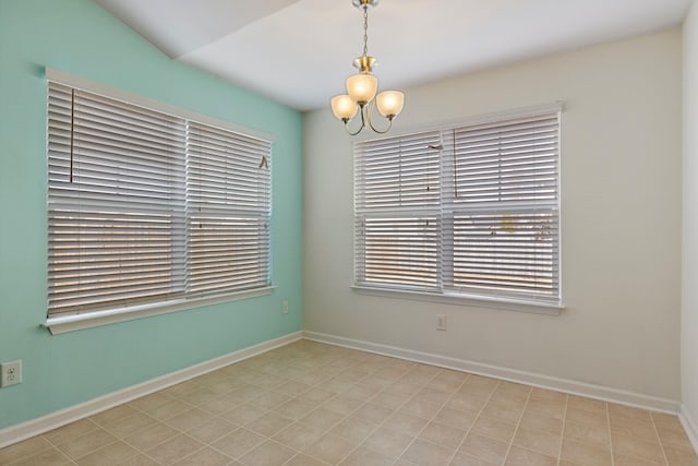 empty room featuring a chandelier and vaulted ceiling