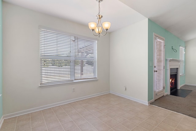 unfurnished room featuring a notable chandelier and light tile patterned floors