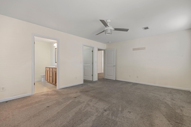 unfurnished bedroom with connected bathroom, ceiling fan, and light carpet