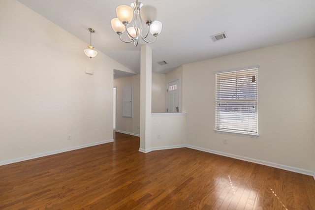 unfurnished room with dark hardwood / wood-style flooring, vaulted ceiling, and a notable chandelier