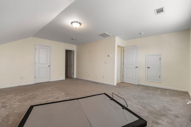 bonus room with light colored carpet and vaulted ceiling