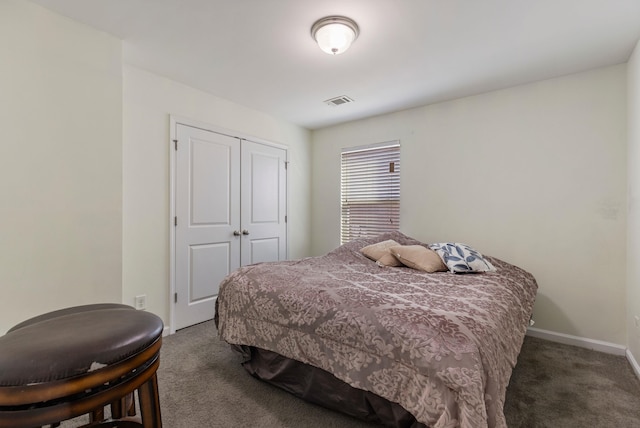 bedroom with dark carpet and a closet