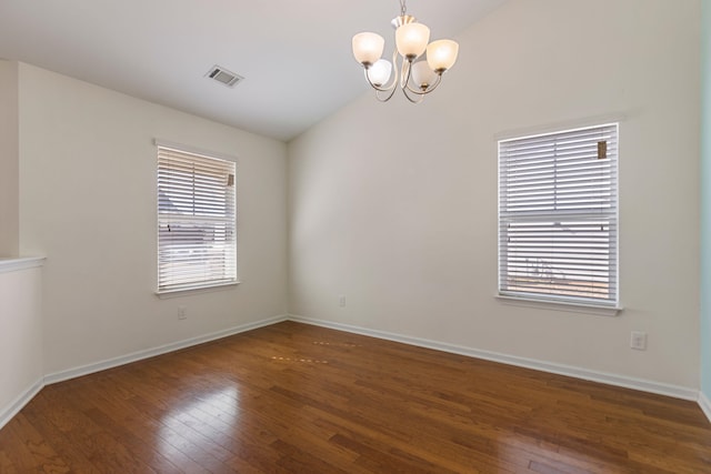 unfurnished room with a notable chandelier, dark wood-type flooring, and vaulted ceiling